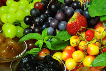 closeup fresh fruits: grapes, strawberry, cherry and mint with s