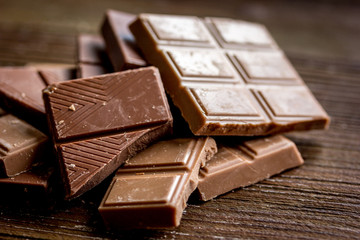 chopped chocolate pieces for dessert dark wooden desk background