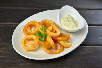 Fried onion rings. Fast food on hardwood