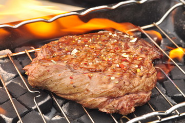 BBQ steak on the grill with flames