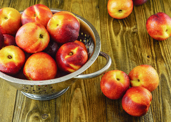 Plenty mellow orange red nectarines on rough rustic wooden background selective focus.