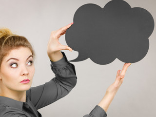 Serious woman holding black thinking bubble