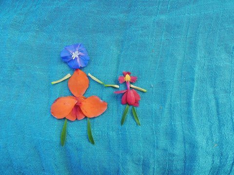 Desenho de mulher e criança montado com delicadas pétalas de flores coloridas sobre  fino tecido azul mar