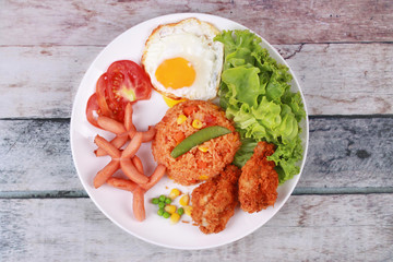 American fried rice topped sunny up,sausage.chicken and herbs