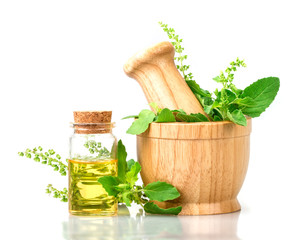  basil in wooden mortar with essential oil , alternative herbal medicine and aromatherapy concept