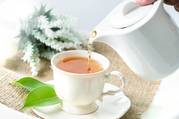 Close up pouring hot black tea in a white tea cup ,  Tea ceremony time concept