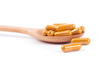 Close up turmeric capsule in spoon on white background