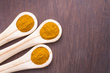 turmeric powder on wood background (curcuma longa)