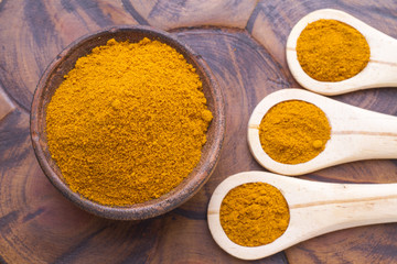 turmeric powder on wood background (curcuma longa)