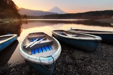 Gardinen Beautiful scenery during sunrise of Lake Saiko in Japan with the rowboat parked on the waterfront and Mountain Fuji background. Travel and Attraction Concept © goodze