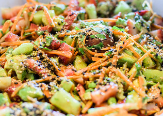 Healthy vegetarian salad with carrots, tomatoes, cilantro and sesame seeds.