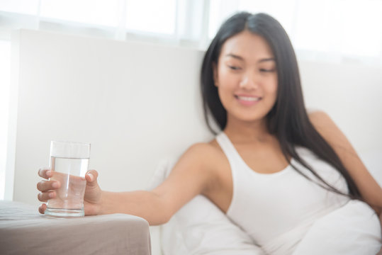 Close up Asian Woman holding glass of water.