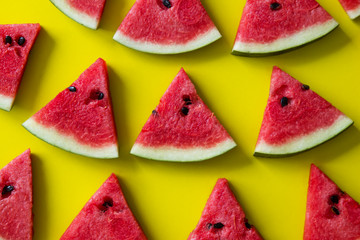 Pieces of red watermelon on yellow background.