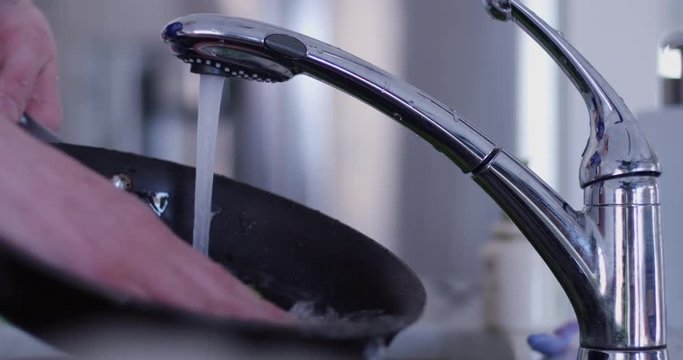 hand washes frying pan- slow motion