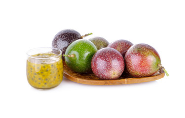 a glass of passion fruit juice with whole passion fruit in basket and on white background