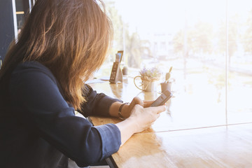 business concept. businesswomen sitting at table in coffee shop, using smartphones and discuss business strategy with soft-focus in the background. over light