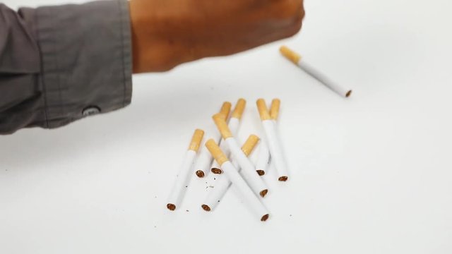 Video footage of male hand breaking cigarettes with his fist, isolated on white background. Stop smoking concept