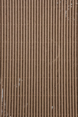 Abstract background of beige corrugated cardboard texture, flat lay. Rough brown backdrop with free space for text.