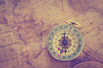 Old vintage retro golden compass on ancient map