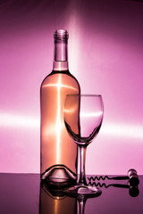A bottle of white wine is an empty glass and a corkscrew
