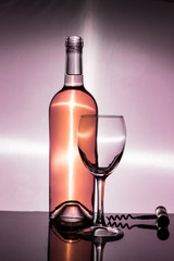 A bottle of white wine is an empty glass and a corkscrew
