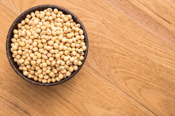 Soybean in wooden bowl put on wooden plank background