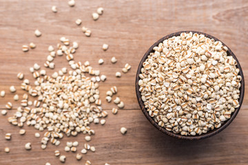 Millet rice or millet grains in wooden bowl put on wooden table background