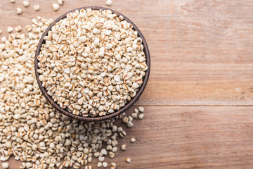 Millet rice or millet grains in wooden bowl put on wooden table background