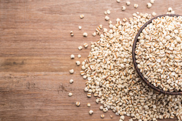 Millet rice or millet grains in wooden bowl put on wooden table background