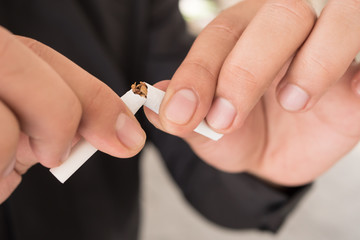 man quit smoking, breaking cigarette, concept of healthy lifestyle decision