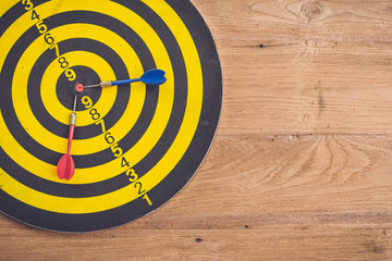 Dart arrow and dartboard on brown wooden background. Composition white free space for text or design