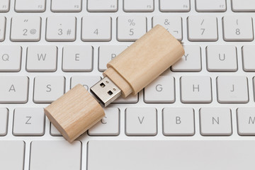 USB flash drive wooden on white keyboard
