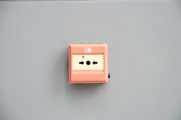 wall mounted Red fire alarm button used to activate warning systems in buildings