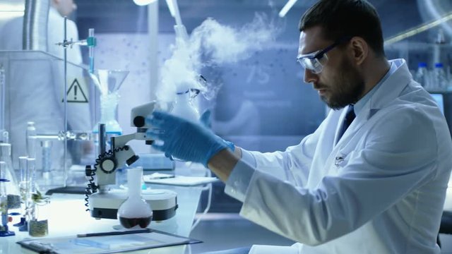In a Chemical Research Laboratory Scientist Mixes Smoking Compounds in Beakers. Shot on RED EPIC-W 8K Helium Cinema Camera.