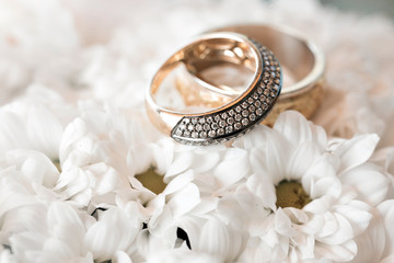 Wedding rings on a white flowers pillow. accessories wedding closeup. selective focus