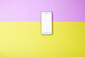 blank Smart phone on pink and yellow background. flat lay. top view.