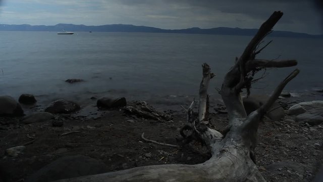 Lake Tahoe, California - August, 2012 - Time-lapse of water washing up on the beach with a fallen tree in the foreground by McKinney Bay Pier.