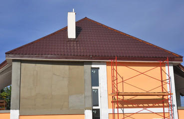 Roofing Construction. Roof Repair. Stucco and painting house wall during renovation with Soffit...
