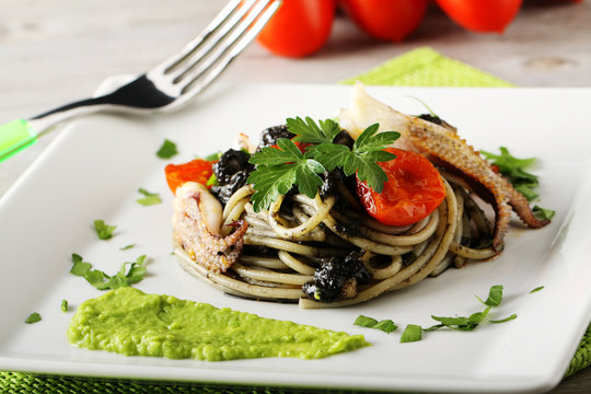 Spaghetti with black sepia, parsley and cherry tomatoes