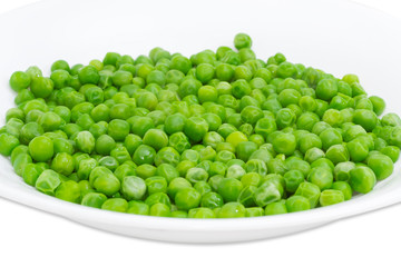 Blanched green peas in white dish closeup