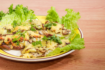 Pork chops baked with onion, mushrooms and cheese
