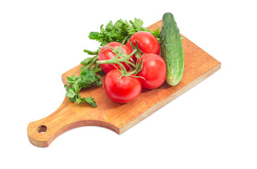 Branch of tomatoes, cucumber and parsley on cutting board