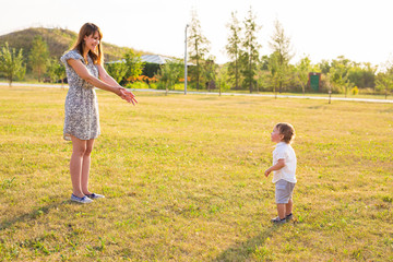 Happy laughing little boy playing in nature with mother