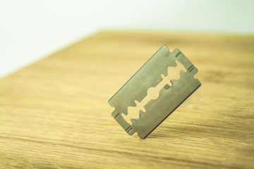 Razor blade over the wooden board