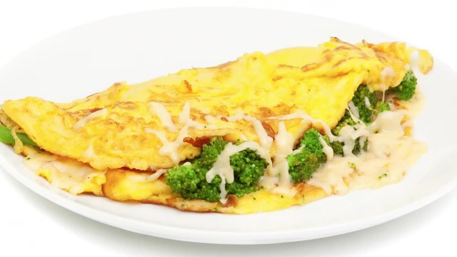 omelet with cheese and broccoli on a white plate zoom out