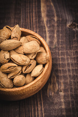crude almonds on a wooden background/almonds in a wooden plate close up