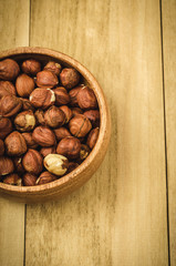 nuts in a plate on a wooden background top view/nuts in a plate on a wooden background