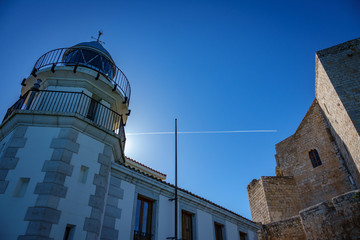 Wide angle backlit of lighthouse and castle