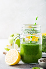 Healthy green smoothie with spinach, banana, lemon, apple and chia seeds in glass jar and ingredients. Detox, diet, healthy, vegetarian food concept with copy space.