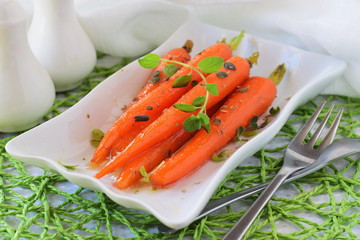 Honey glazed carrots on a white plate. Healthy eating concept